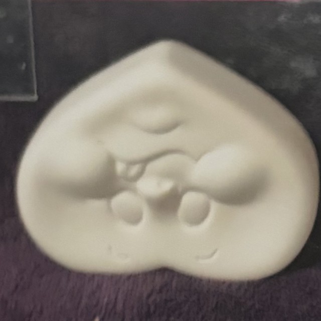 Heart face, unpainted bisque, front view on black velvet