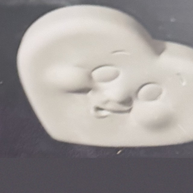 Heart face, unpainted bisque, front view on black velvet